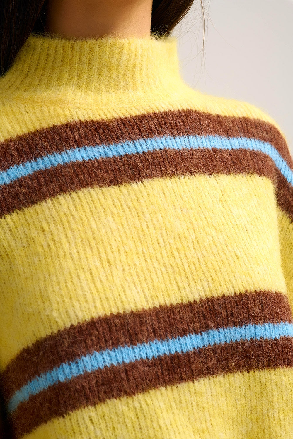 Camisola de malha amarela com riscas castanhas e azuis