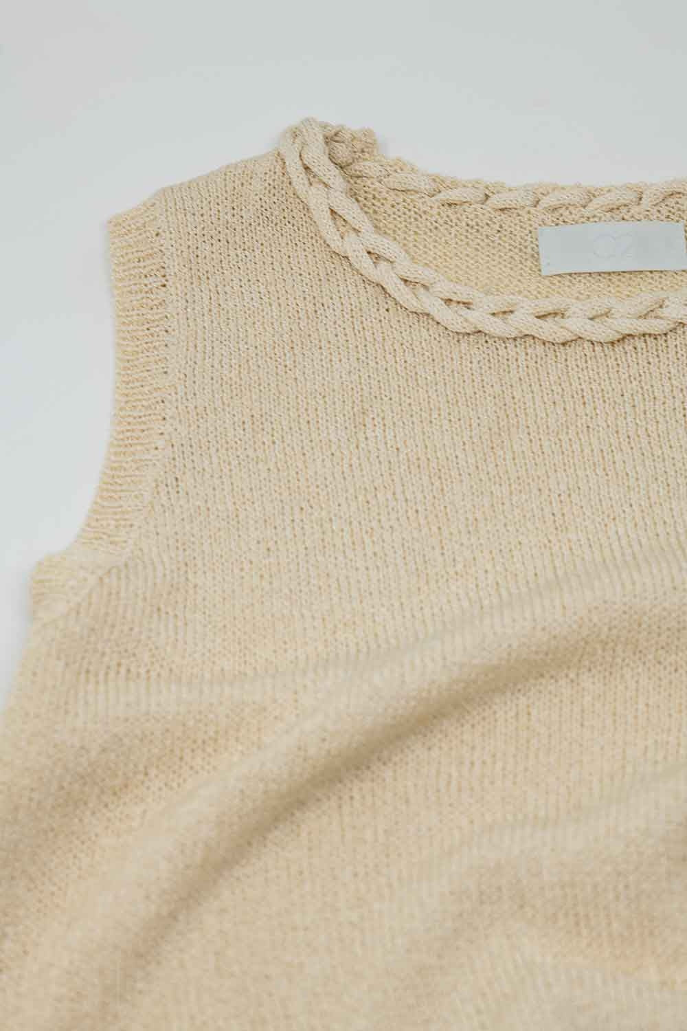 Camisola sem mangas em bege com decote em gola alta e pormenor de tranças no decote