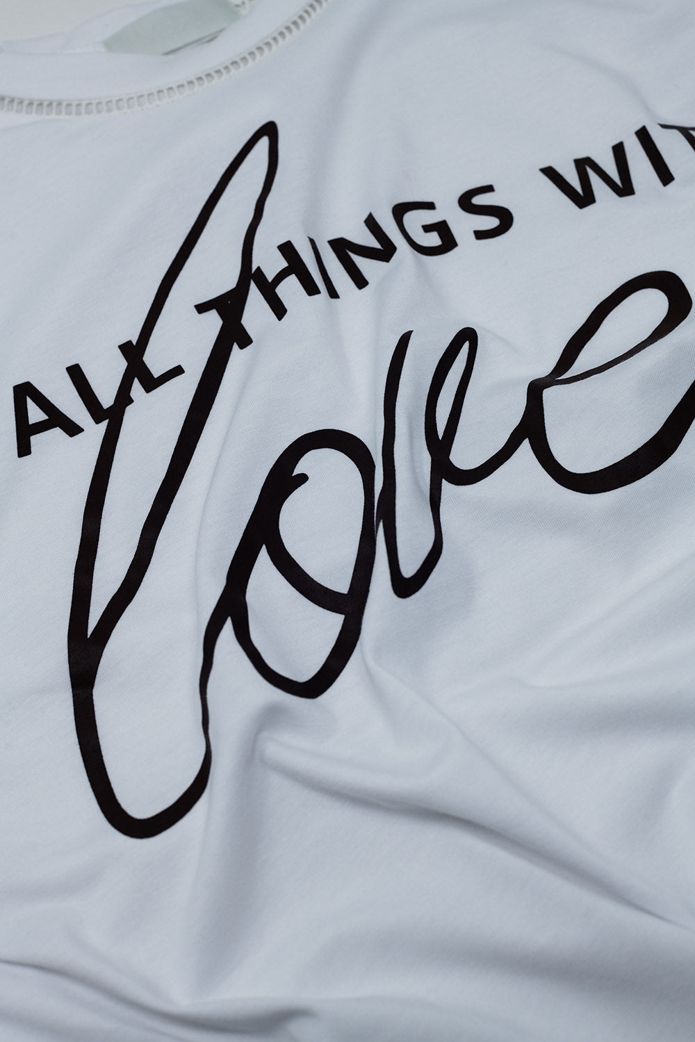 T-Shirt branca com texto preto na frente e rebordo no pescoço