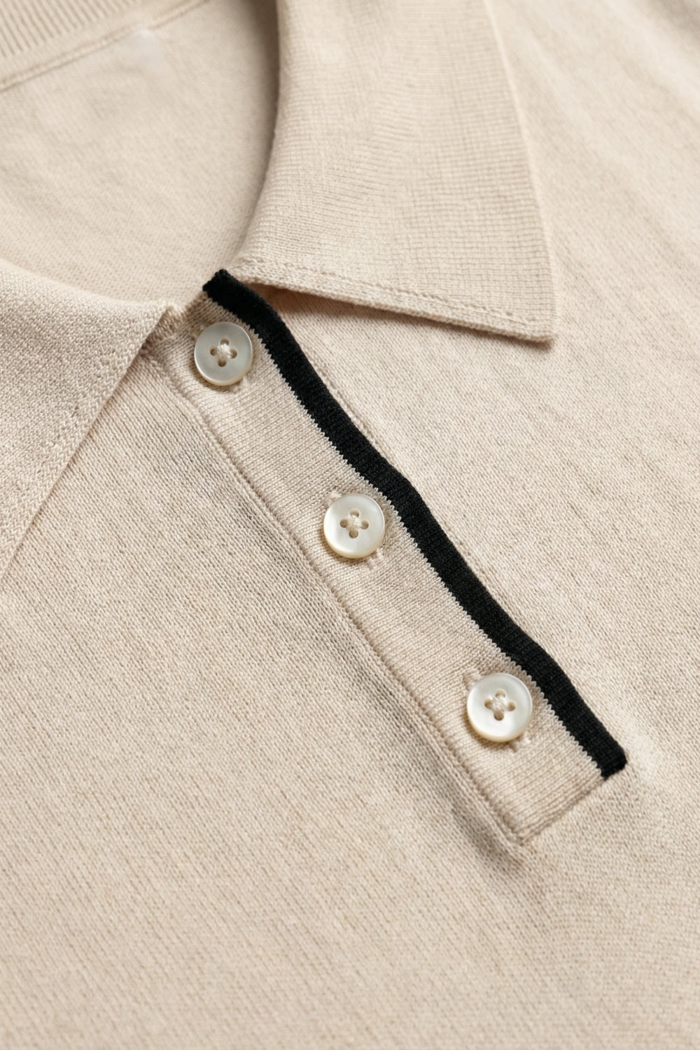Top polo de malha bege com pormenor de guarnição preto
