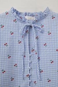 Blusa azul clara com pormenores em cereja e laço atado