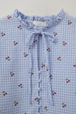 Blusa azul clara com pormenores em cereja e laço atado