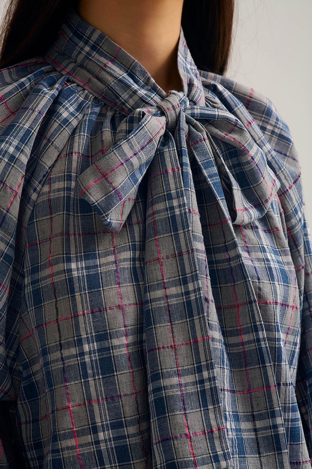 Blusa azul com estampado xadrez e pormenor de laço no pescoço