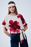 Blusa bege cortada com estampado floral tropical em vermelho atado na cintura