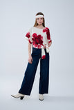 Blusa bege cortada com estampado floral tropical em vermelho atado na cintura