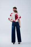 Blusa bege cortada com estampado floral tropical em vermelho atado na cintura