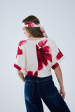 Blusa bege cortada com estampado floral tropical em vermelho atado na cintura