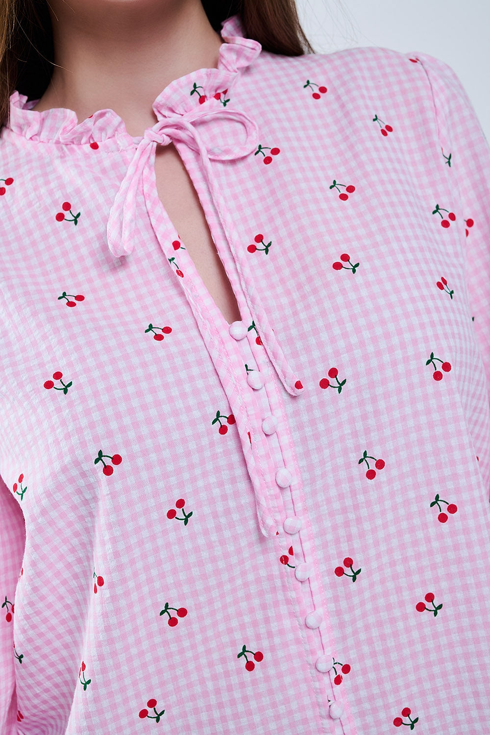 Blusa cor-de-rosa com pormenores de cerejas e laço atado