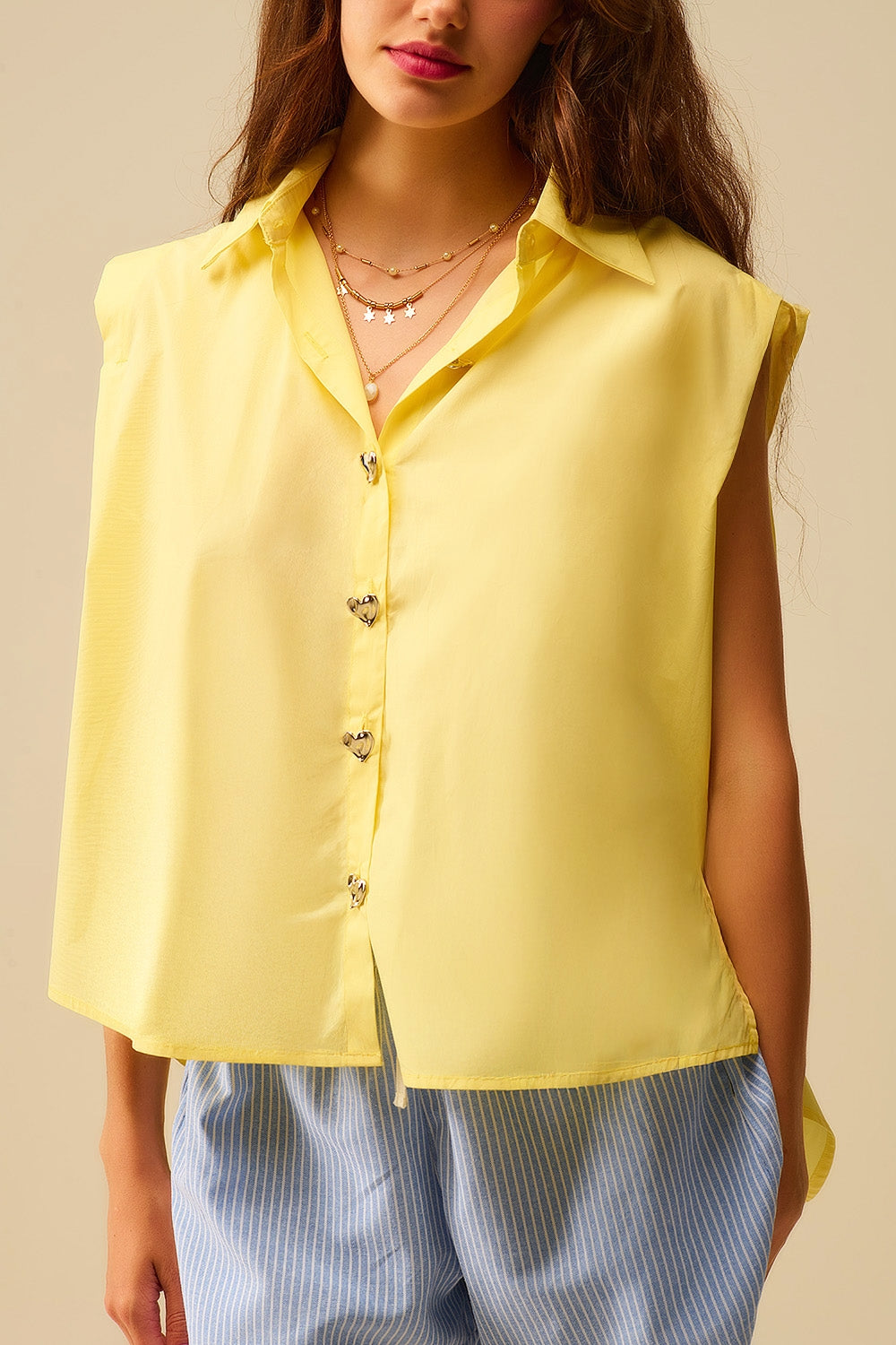 Q2 Blusa sem mangas amarela com botões em forma de coração