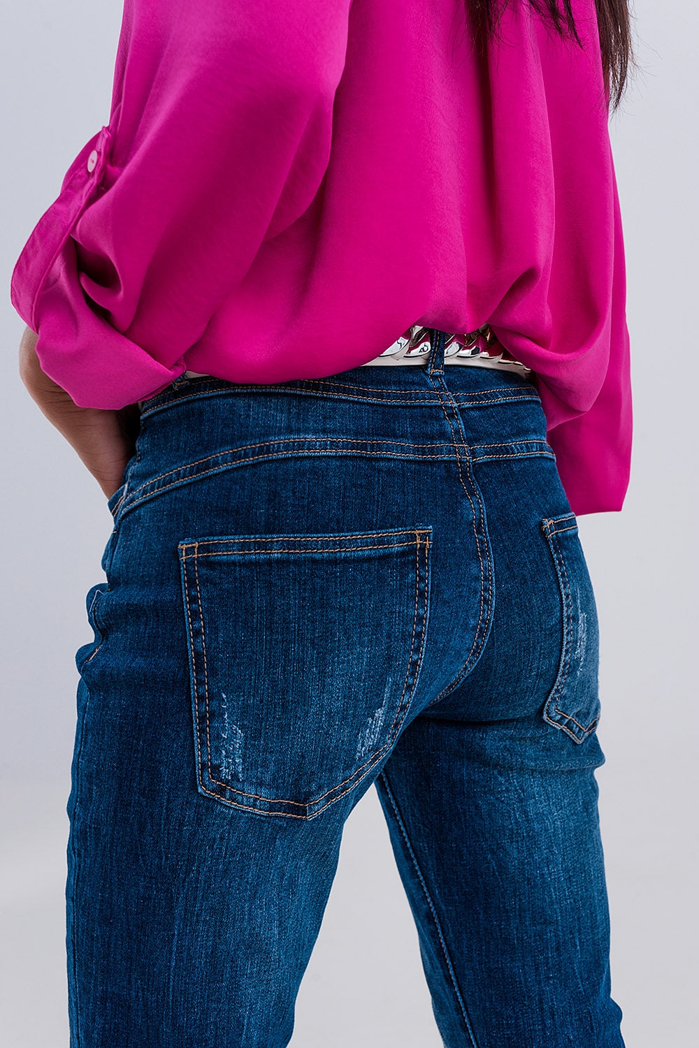 Calças de ganga de perna direita com botões visíveis em azul escuro