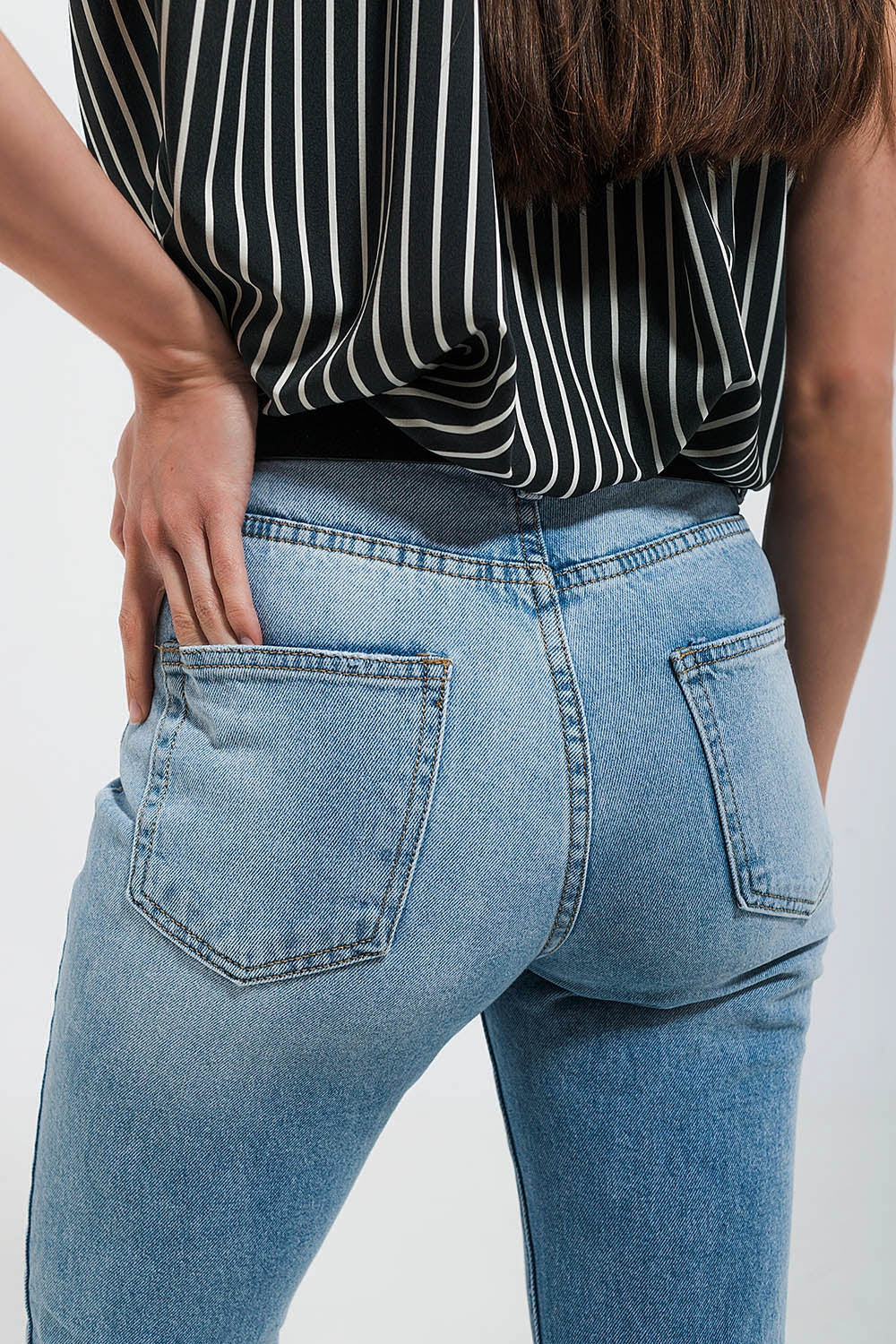 Calças de ganga esticadas com lavagem ligeira e bainhas em bruto