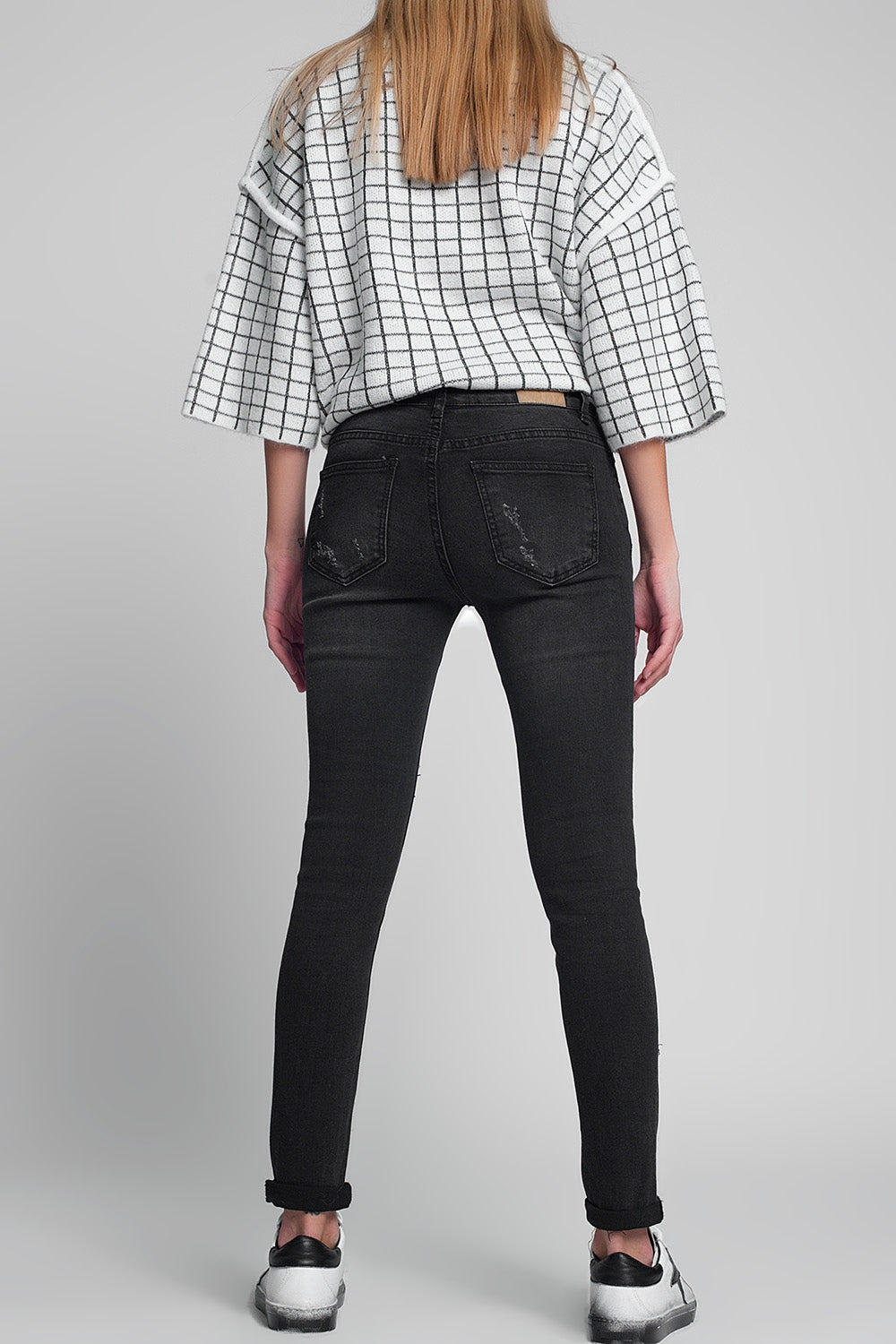 Calças de ganga rasgadas e bem ajustadas em preto descolorido