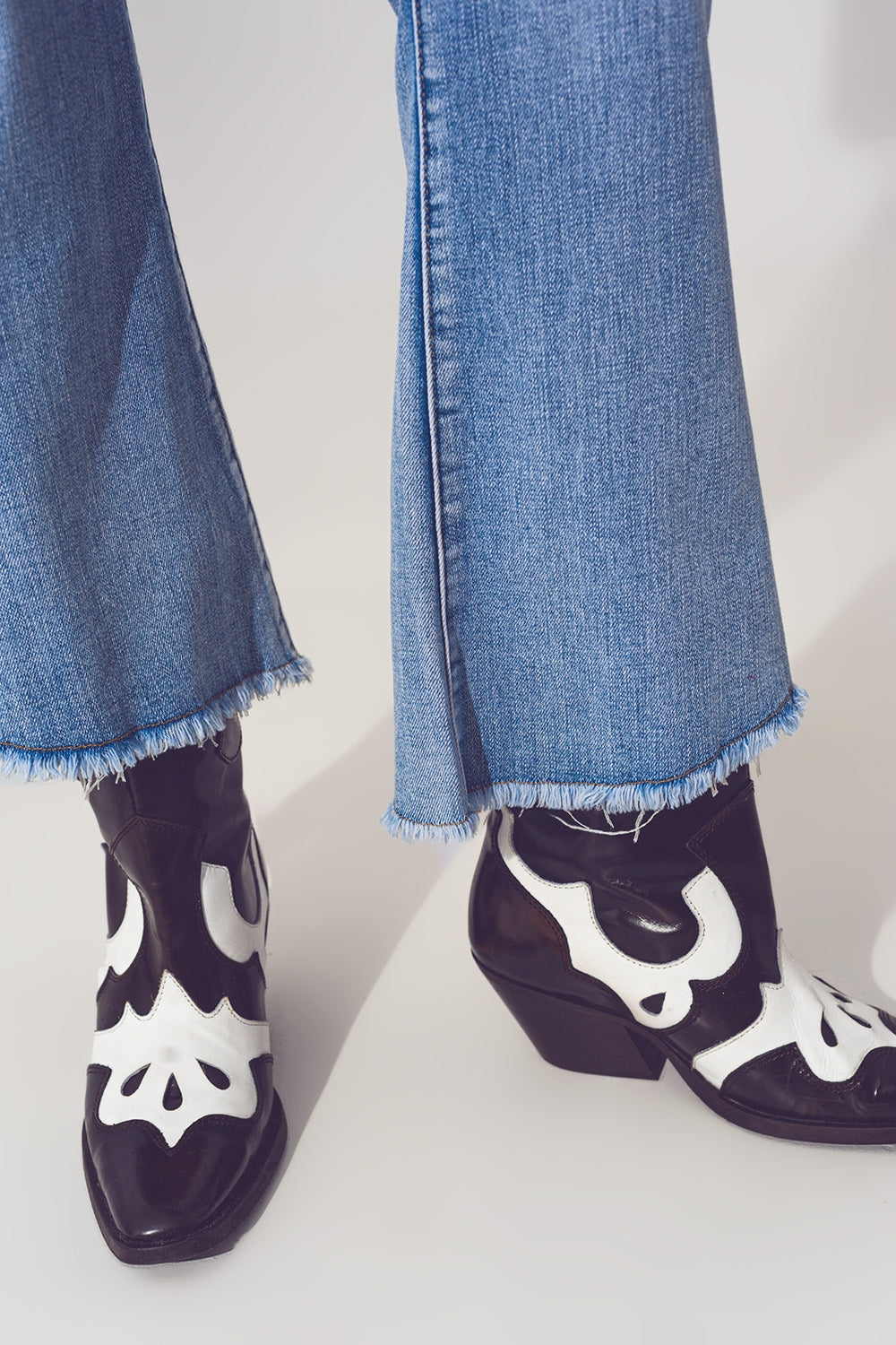 Calças de ganga rasgadas em azul claro com bainha assimétrica