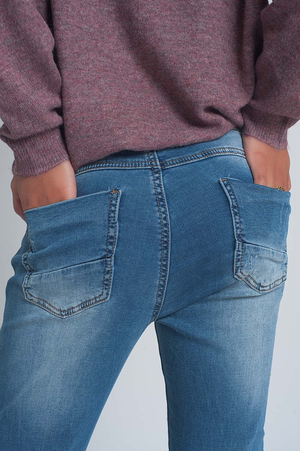 Calças de ganga rasgado em tejido fino no meio da lavagem