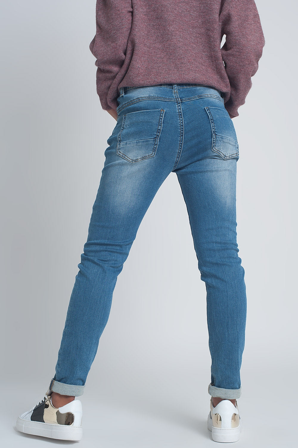 Calças de ganga rasgado em tejido fino no meio da lavagem