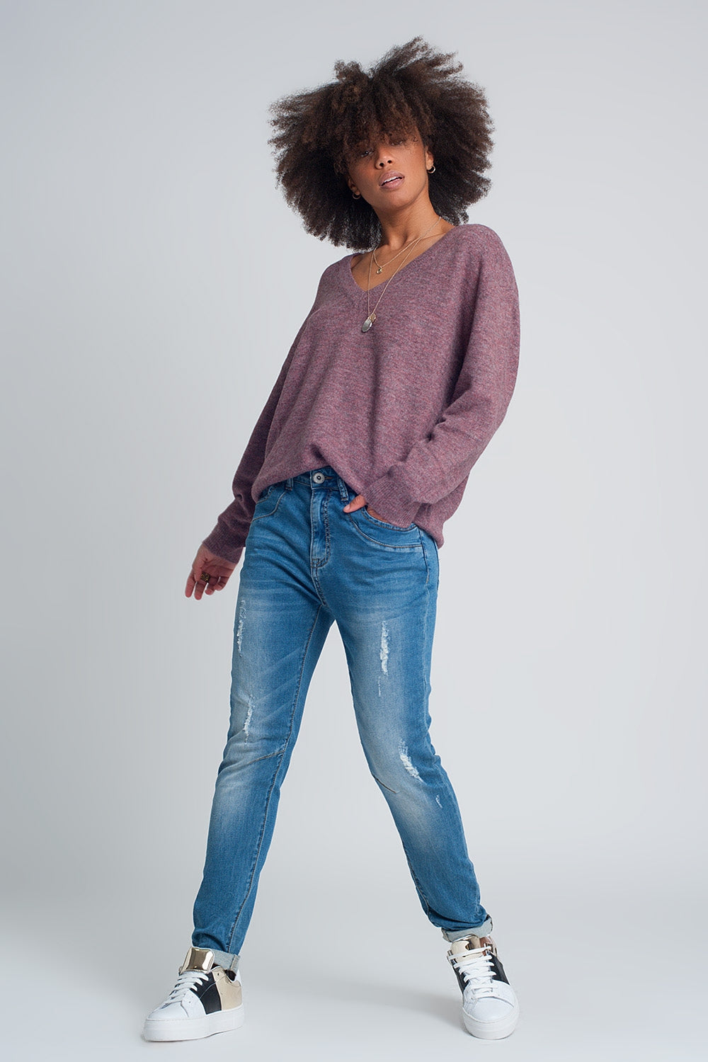 Calças de ganga rasgado em tejido fino no meio da lavagem