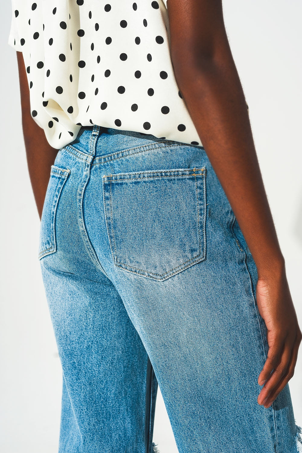 Calças de ganga rectas de lavagem média com rasgos e fendas no fundo