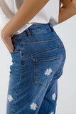 Calças de ganga skinny com margaridas brancas estampadas em lavagem média