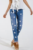 Calças de ganga skinny com margaridas brancas estampadas em lavagem média