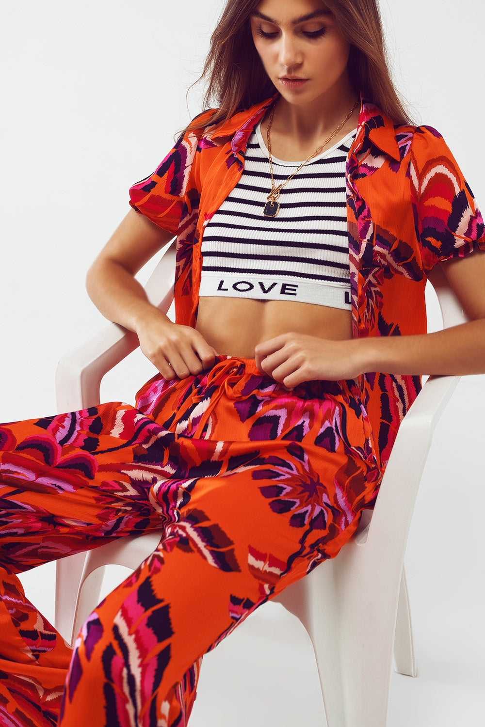Calças estilo palazzo com estampa floral abstrata em laranja