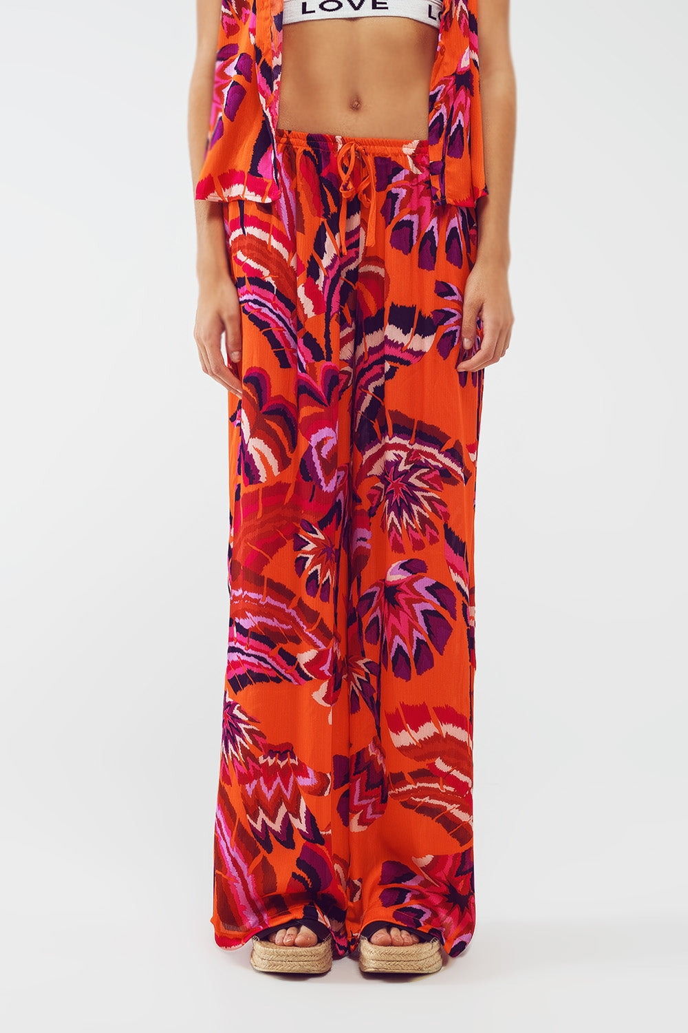 Calças estilo palazzo com estampa floral abstrata em laranja