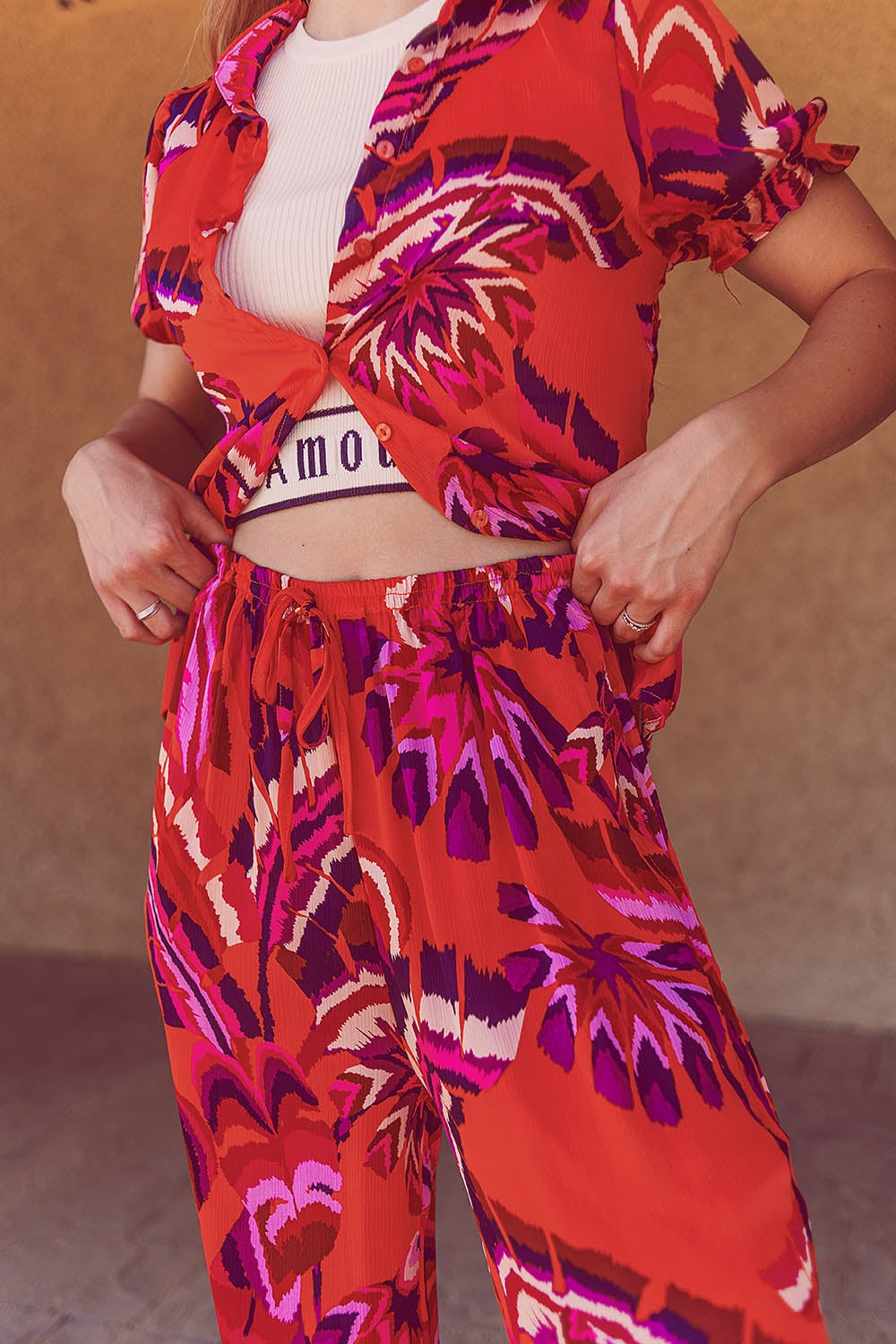 Calças estilo palazzo com estampa floral abstrata em laranja