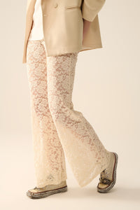 Calças flare de creme em renda floral