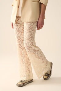 Calças flare de creme em renda floral