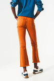 Calças jeans flare com bainha desfiada em laranja