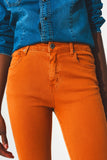 Calças jeans flare com bainha desfiada em laranja