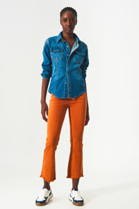 Calças jeans flare com bainha desfiada em laranja