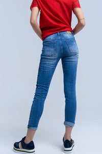 Calças jeans magras com flores pintadas