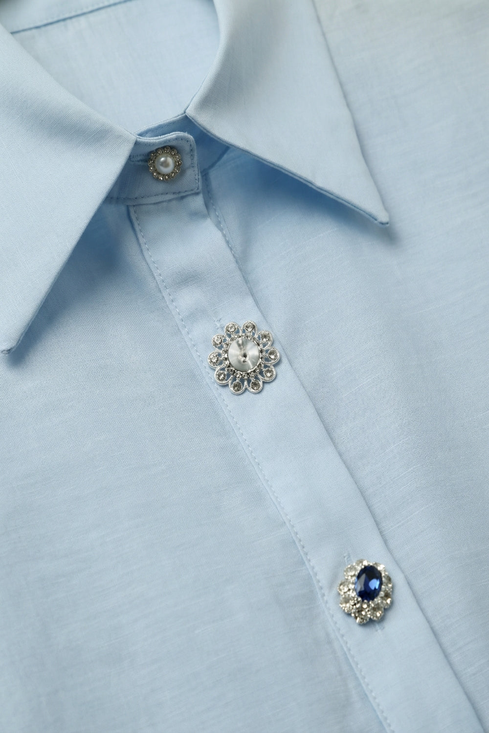 Camisa azul-clara de cetim com botões manga longa e dois botões no punho