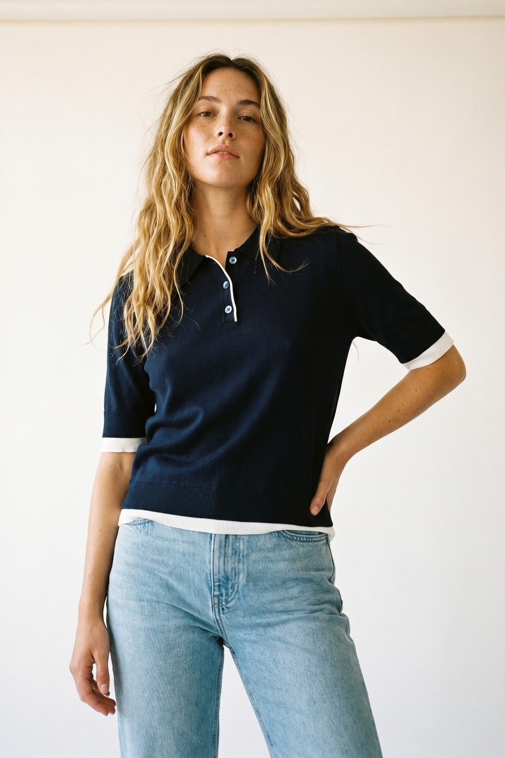 Camisa pólo azul-marinho com rebordo branco e pormenor de botões