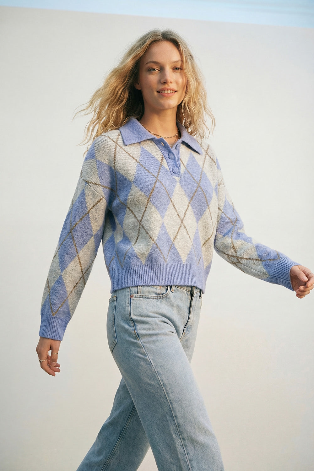 Q2 Camisola de malha azul com padrão de losangos e gola polo.