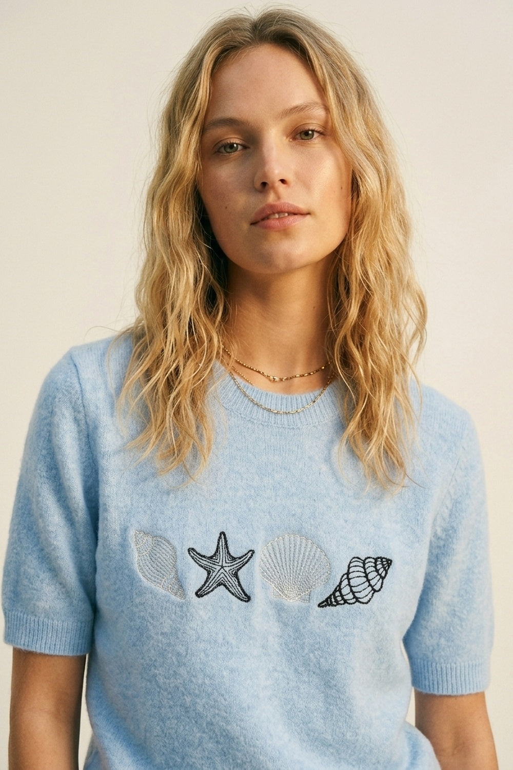 Camisola de manga curta em malha azul clara com conchas