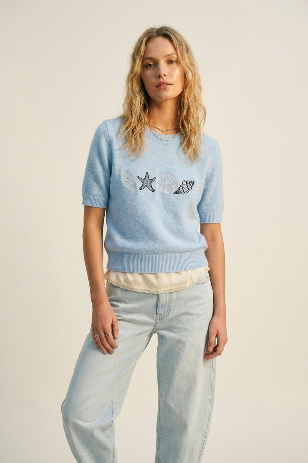 Q2 Camisola de manga curta em malha azul clara com conchas