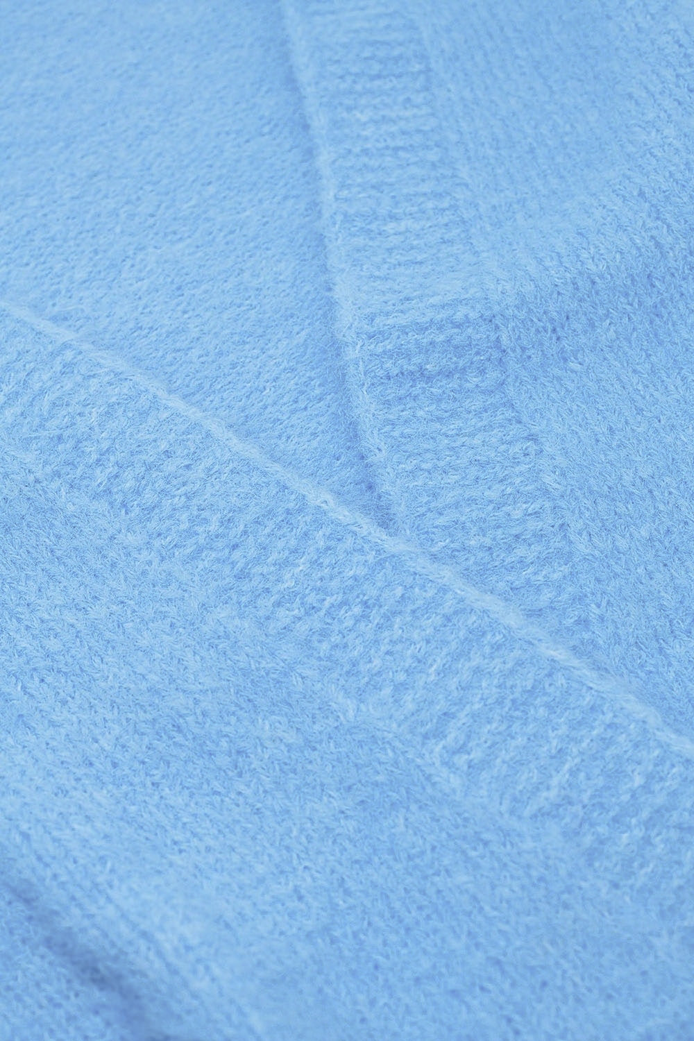 Casaco aberto de malha fofa e descontraída em azul bebé com canelado nos punhos e nas mangas