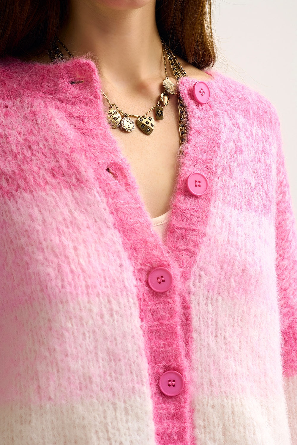 Casaco de malha grisalha cor-de-rosa com textura suave e botões à frente