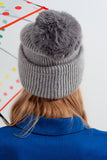 Chapéu de malha cinzenta com pompom