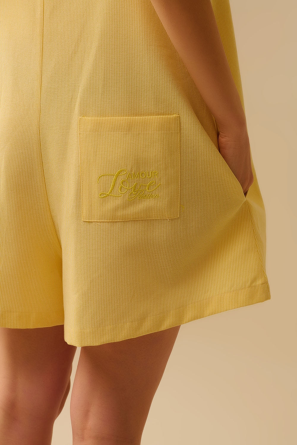 Fato de treino às riscas amarelas com atilhos nos ombros e pormenor de bolso nas costas