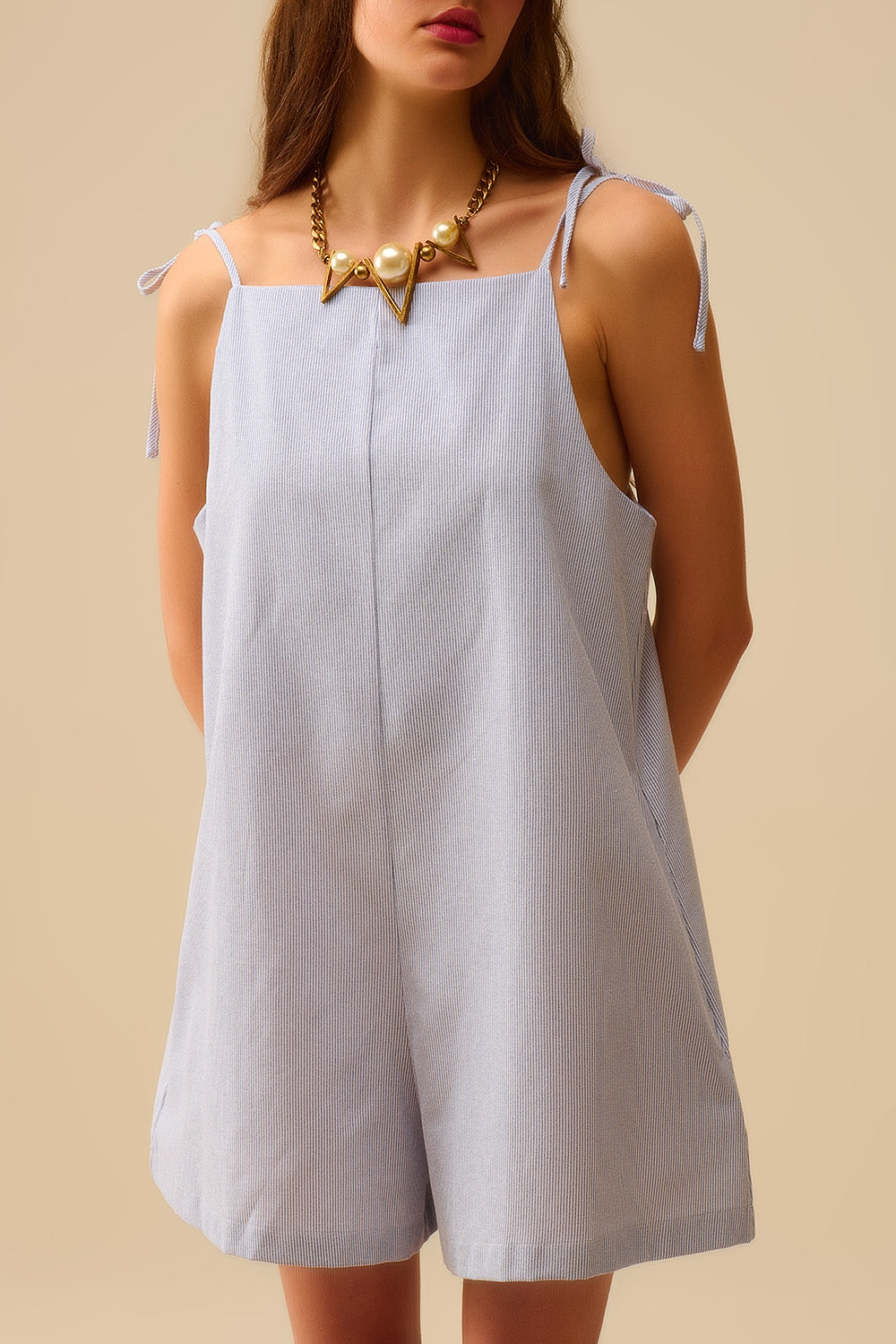 Fato de treino às riscas azuis com atilhos nos ombros e pormenor de bolso nas costas