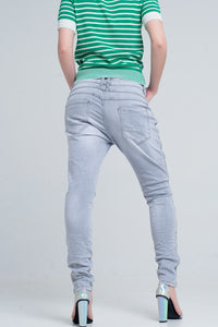 jeans cinza com detalhes de metal no lado