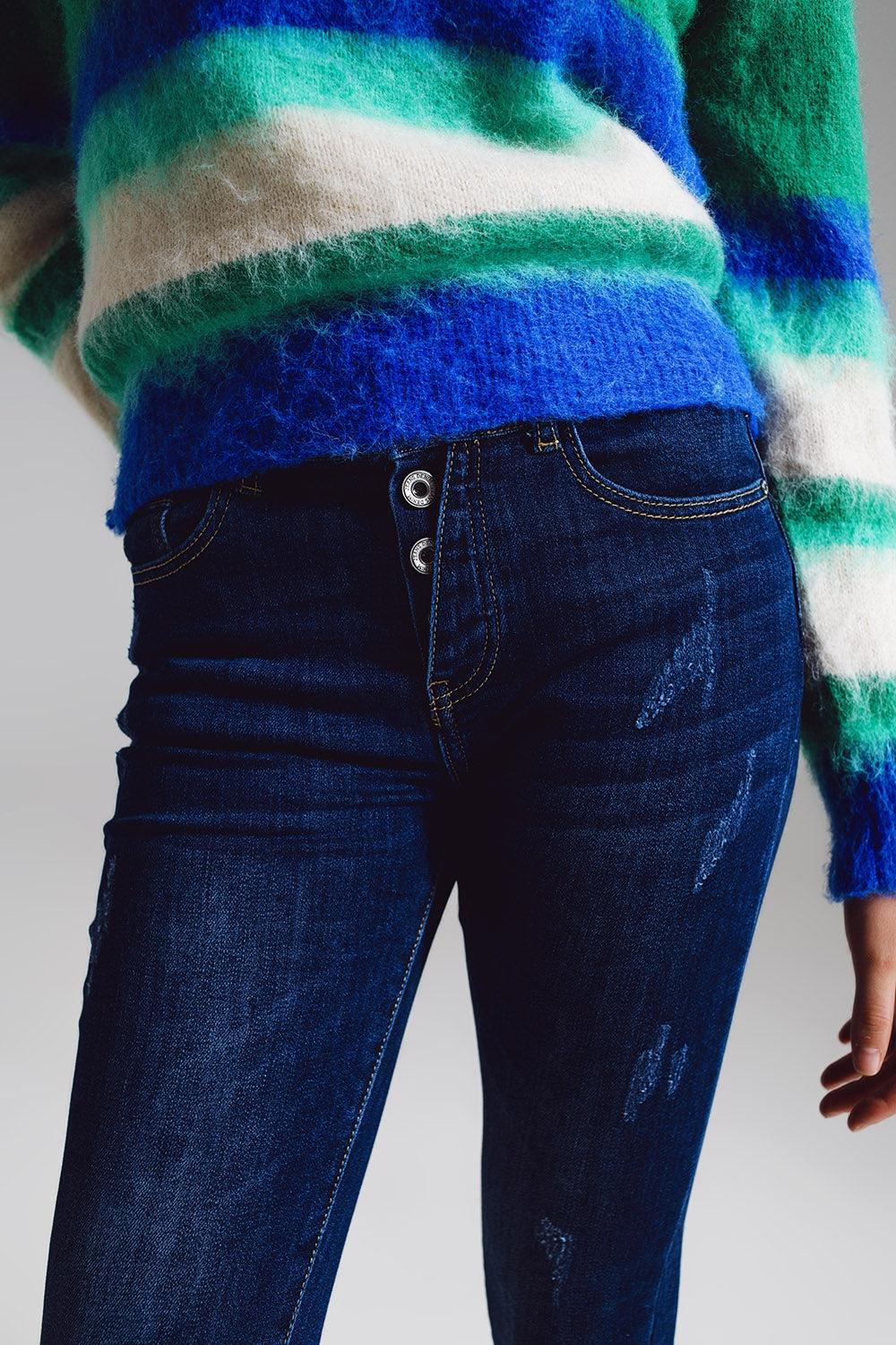 Jeans super skinny com botões frontais visíveis em azul médio