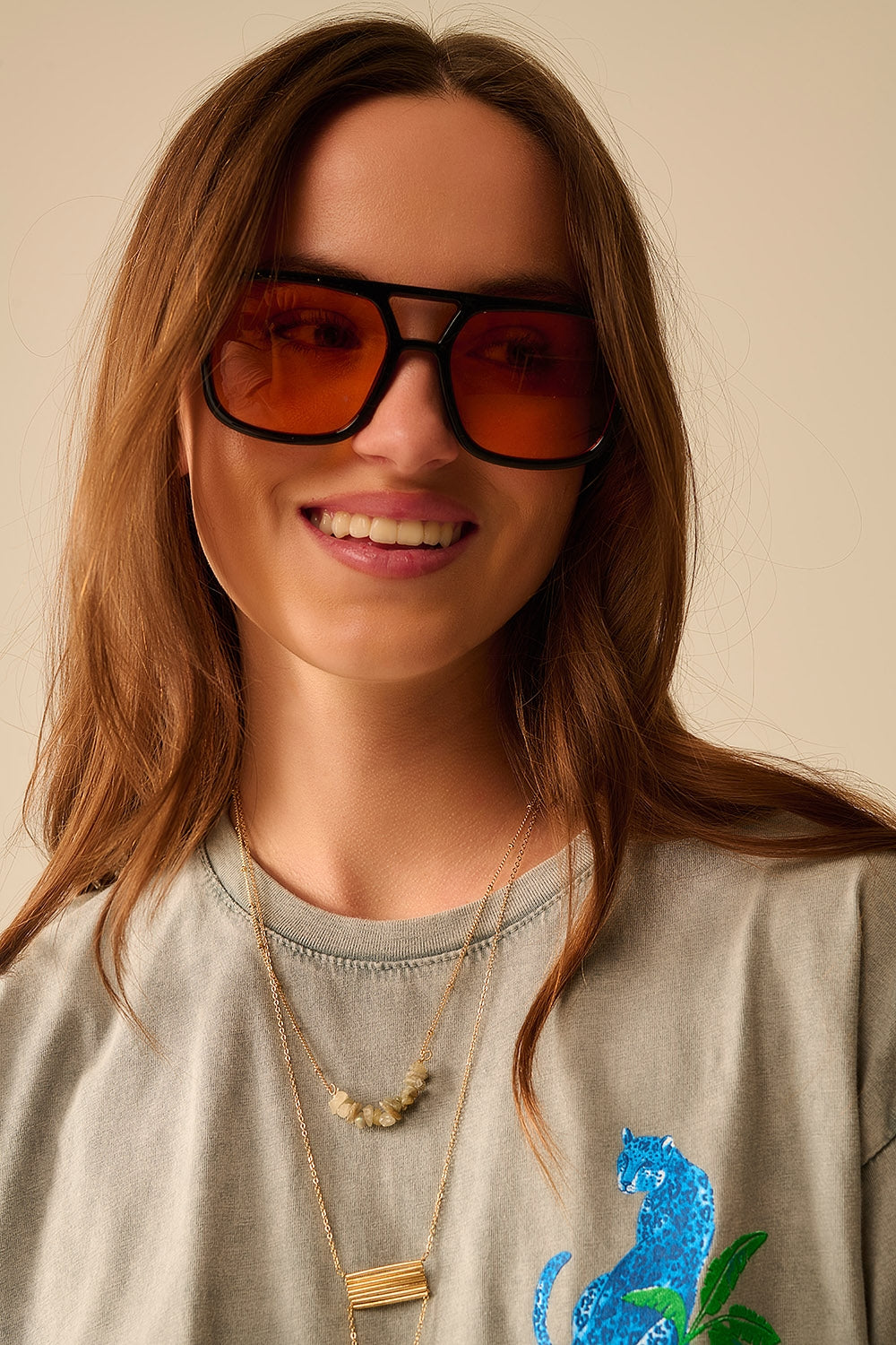 Óculos de sol com armação preta e lentes cor de laranja