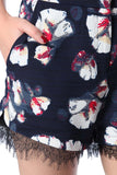 Marinha shorts azuis no impressão floral com detalhe de renda