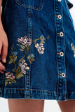 Saia jeans com flores bordadas e botões frontais