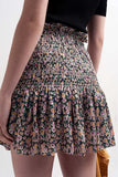 Saia preta com estampado floral e desenho em rufo