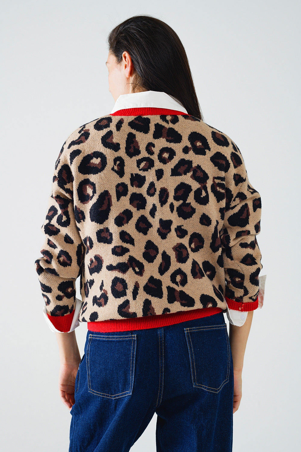 Suéter de leopardo com detalhe vermelho no pescoço e nas mangas