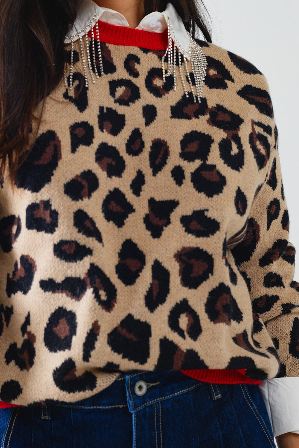 Suéter de leopardo com detalhe vermelho no pescoço e nas mangas